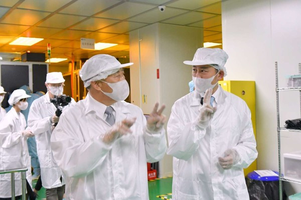 新竹市長林智堅穿上無塵衣，前進隱形眼鏡製程廠區。（圖／新竹市政府提供）